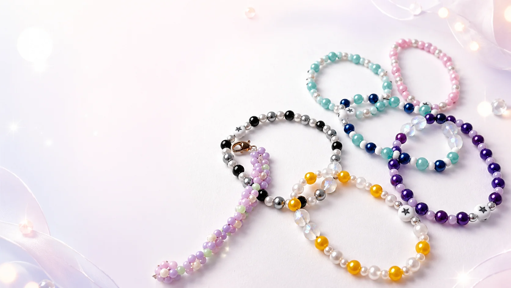 Una colección de pulseras de colores hechas a mano sobre un fondo perlado suave